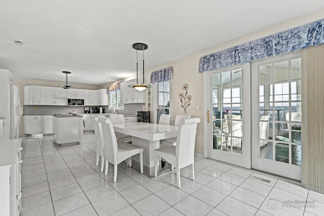 tiled dining space featuring a healthy amount of sunlight