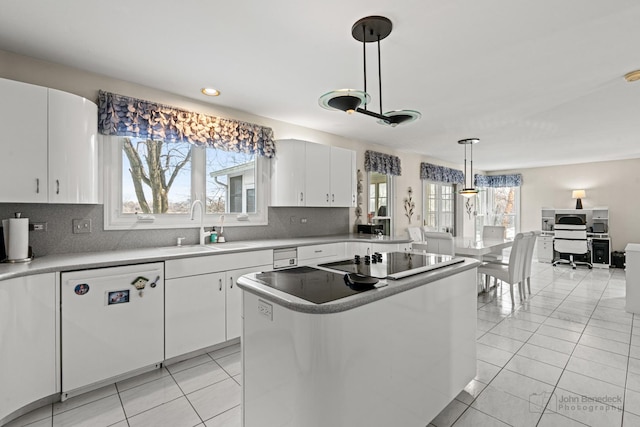 kitchen featuring white cabinets, black electric cooktop, hanging light fixtures, and white dishwasher