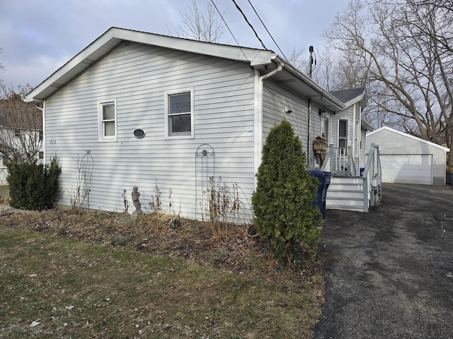 view of side of home featuring a garage and an outdoor structure