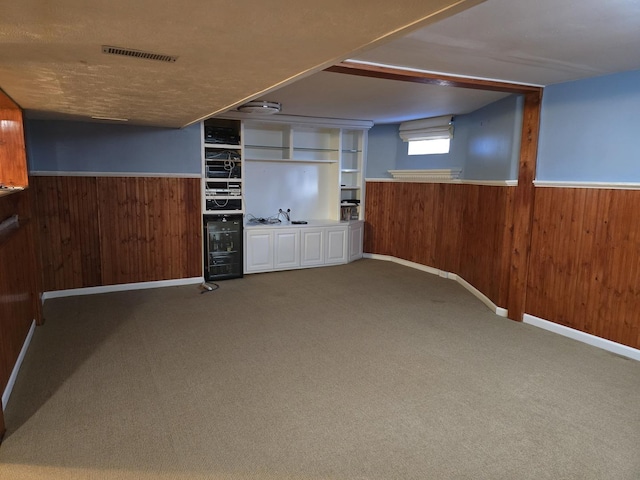 basement with carpet and wood walls