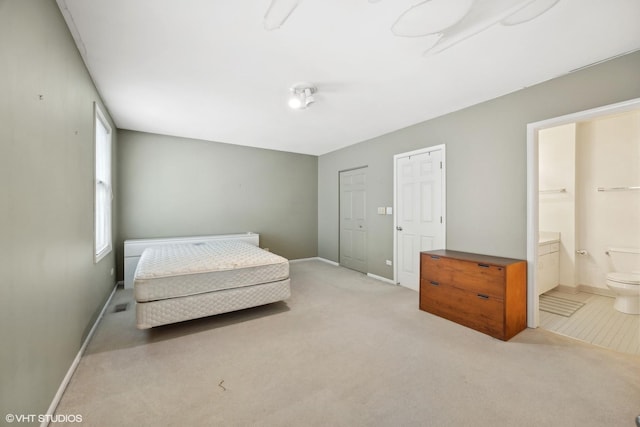 carpeted bedroom featuring ensuite bath