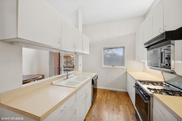 kitchen with white cabinetry, sink, stainless steel appliances, and light wood-type flooring