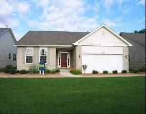 single story home featuring a garage and a front lawn