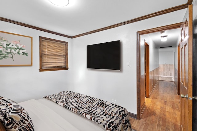 bedroom with hardwood / wood-style flooring and crown molding