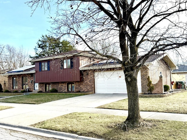 tri-level home featuring a garage and a front lawn