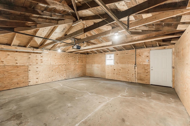 garage with a garage door opener, wooden ceiling, and wood walls