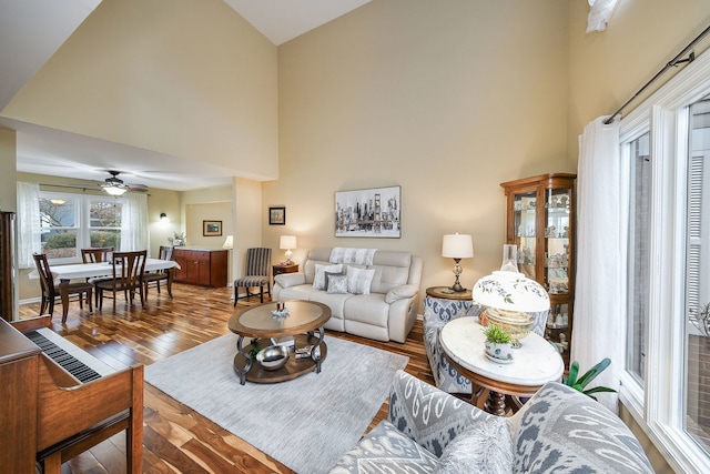 living room featuring wood-type flooring, high vaulted ceiling, and ceiling fan