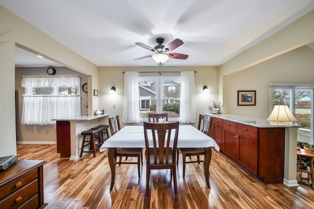 dining space featuring light hardwood / wood-style flooring, ceiling fan, and plenty of natural light