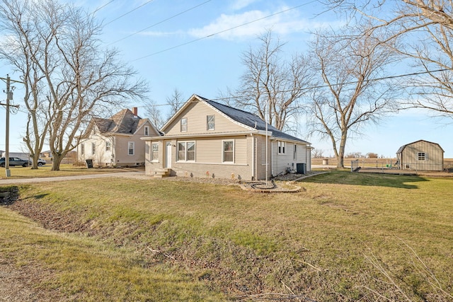 view of side of home with cooling unit, an outdoor structure, and a lawn