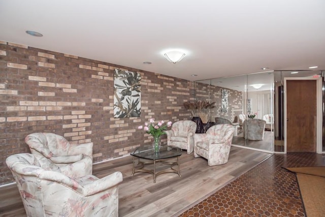 living room featuring wood-type flooring and brick wall