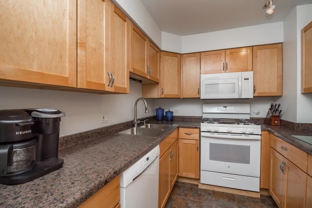 kitchen featuring dark stone countertops, sink, and white appliances