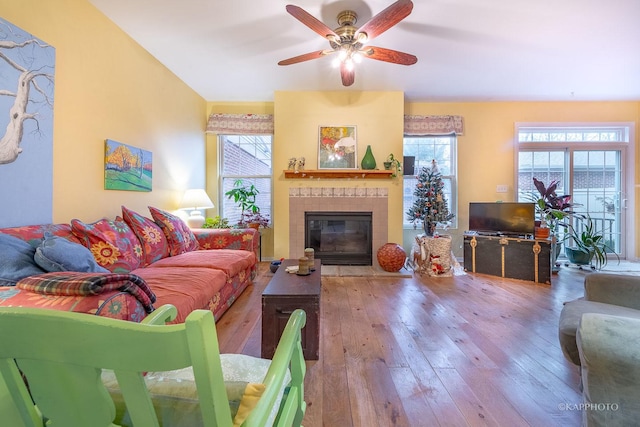 living room featuring ceiling fan, light hardwood / wood-style floors, and a fireplace