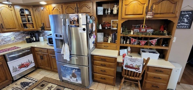 kitchen featuring decorative backsplash, appliances with stainless steel finishes, and light tile patterned flooring