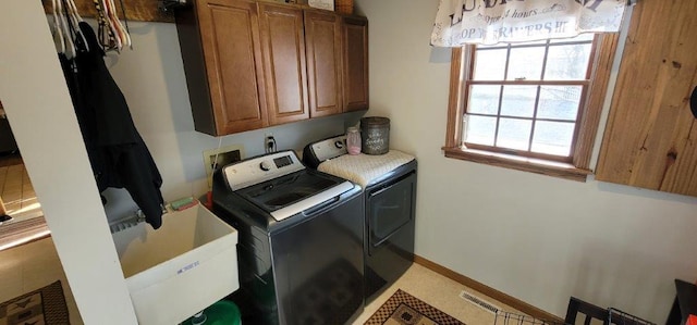 washroom with washer and clothes dryer, cabinets, and sink