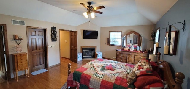 bedroom with ceiling fan, wood-type flooring, and vaulted ceiling