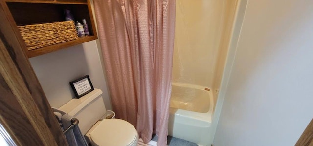 bathroom featuring shower / tub combo and toilet