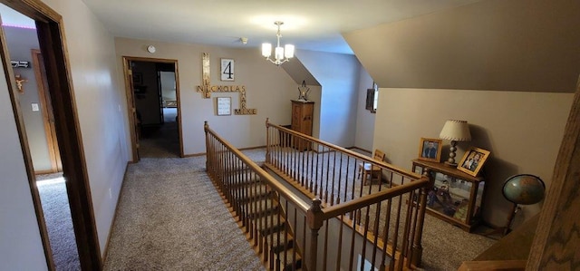 hallway with a notable chandelier and light colored carpet