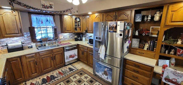 kitchen with decorative backsplash, sink, light tile patterned floors, and stainless steel appliances