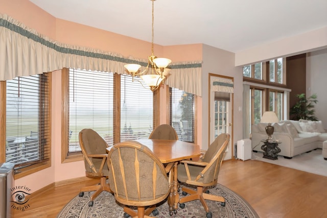 dining area with light hardwood / wood-style flooring and a notable chandelier