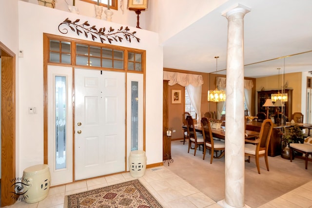 tiled entryway featuring a chandelier and decorative columns