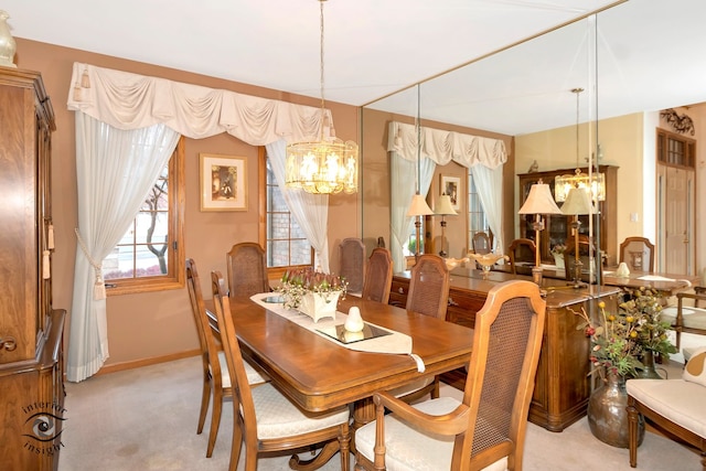 dining space featuring light colored carpet and a chandelier