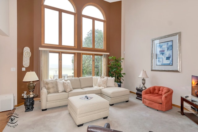 carpeted living room featuring a high ceiling