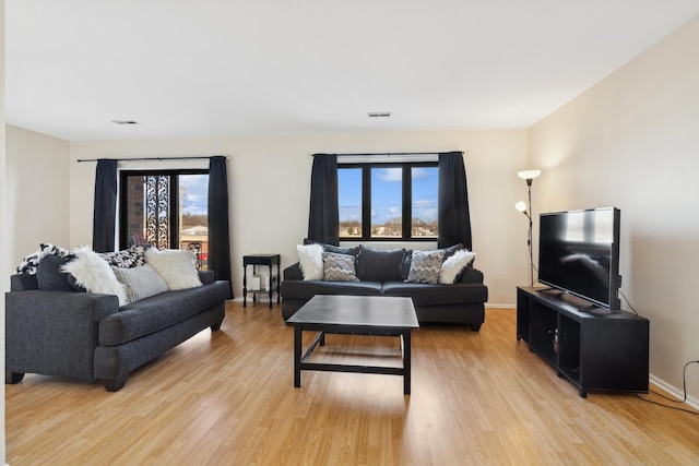 living room with light wood-type flooring and a wealth of natural light