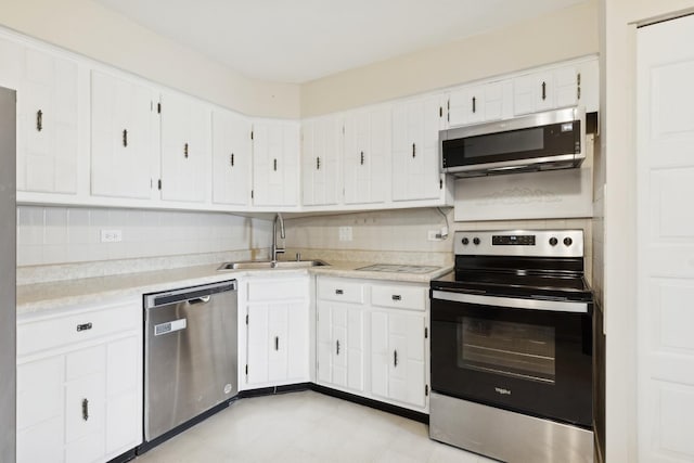 kitchen with tasteful backsplash, sink, white cabinets, and stainless steel appliances