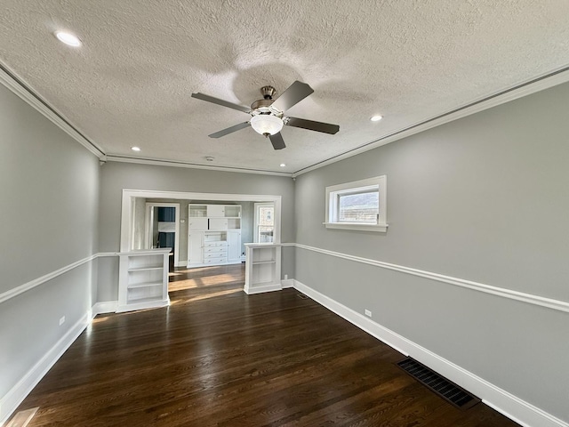 spare room featuring crown molding, dark hardwood / wood-style flooring, and a textured ceiling