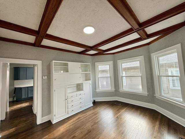 interior space with coffered ceiling, beam ceiling, dark hardwood / wood-style flooring, and multiple windows