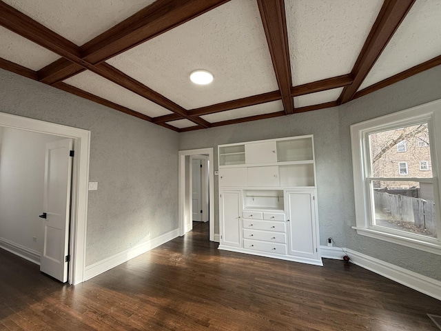 unfurnished bedroom featuring beamed ceiling, a textured ceiling, dark wood-type flooring, and coffered ceiling