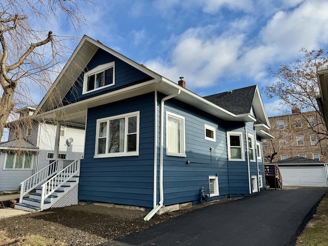 view of side of home with an outdoor structure and a garage