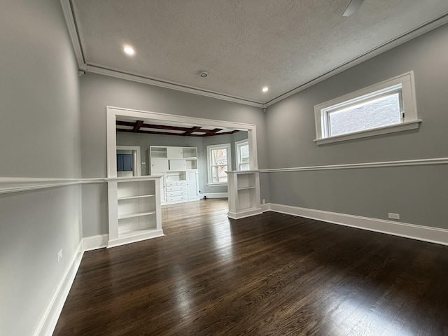 unfurnished living room with ornamental molding, a textured ceiling, and dark wood-type flooring