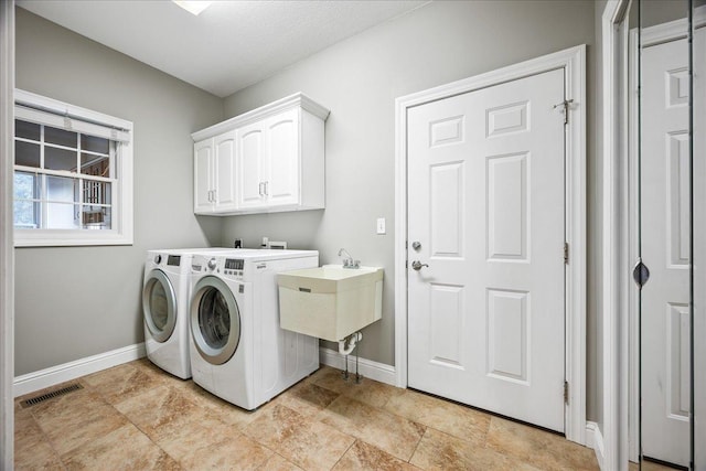 washroom featuring cabinets and washing machine and dryer