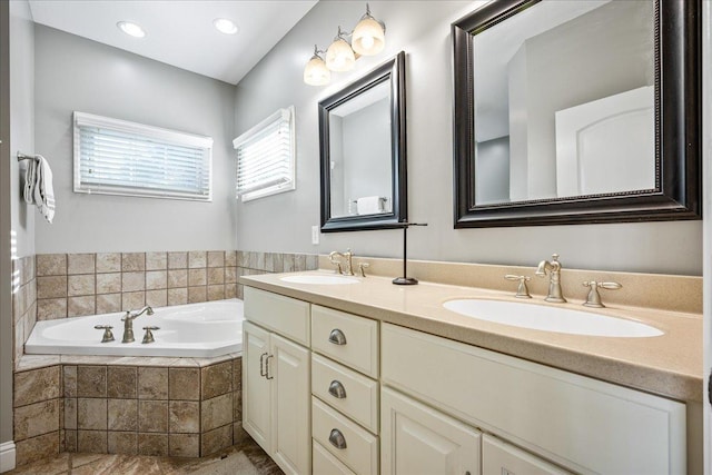 bathroom with vanity and tiled tub