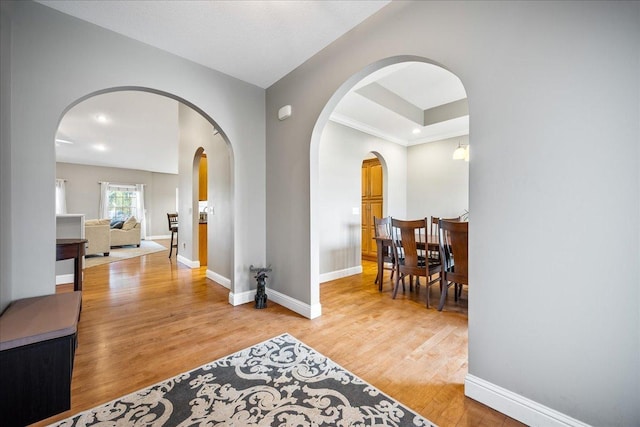 hallway with crown molding and light hardwood / wood-style floors