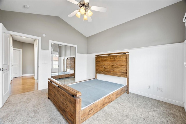 carpeted bedroom with ceiling fan, a closet, and vaulted ceiling