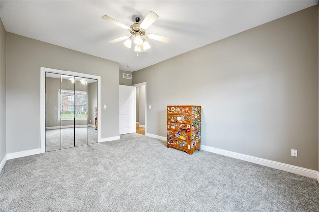 unfurnished bedroom with carpet floors, a closet, and ceiling fan