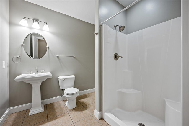 bathroom with tile patterned flooring, toilet, a shower, and sink