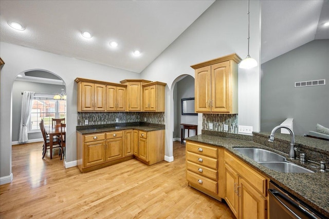 kitchen with pendant lighting, dishwasher, sink, and backsplash