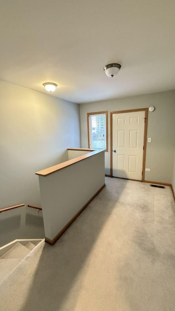 foyer entrance with light colored carpet