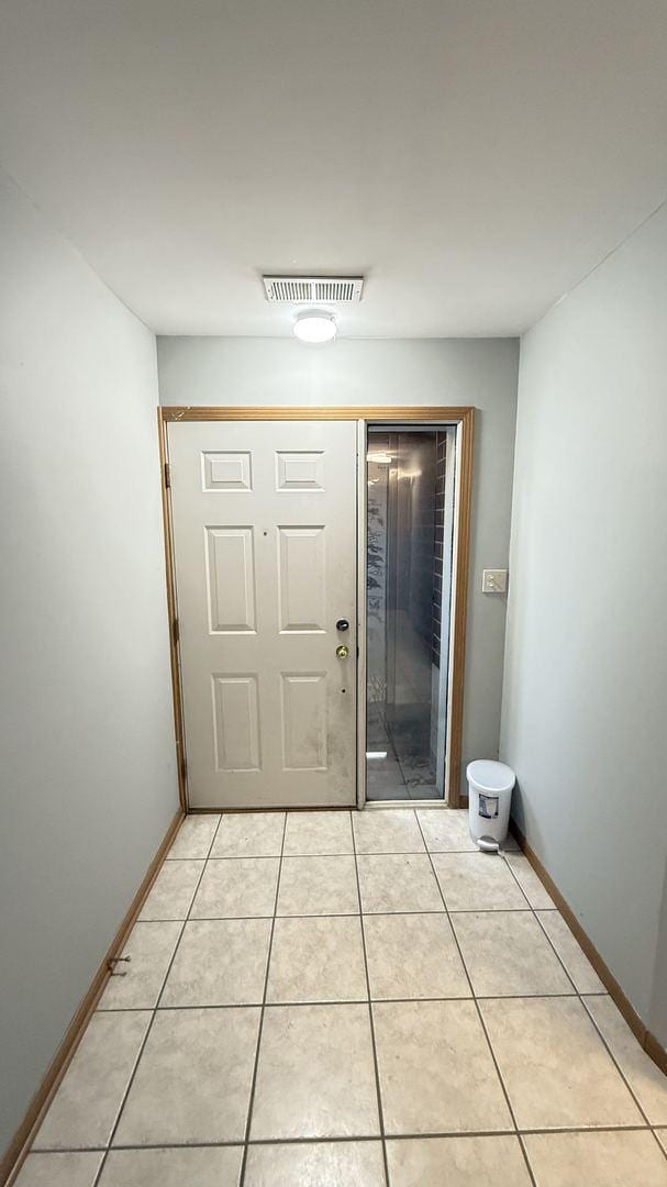 doorway to outside with light tile patterned flooring