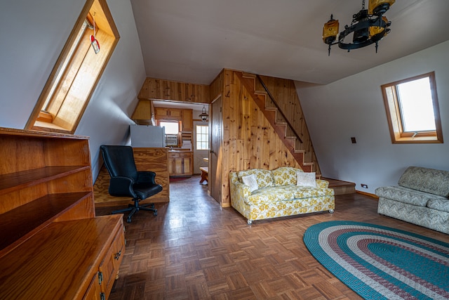 living room featuring dark parquet flooring, plenty of natural light, and wooden walls