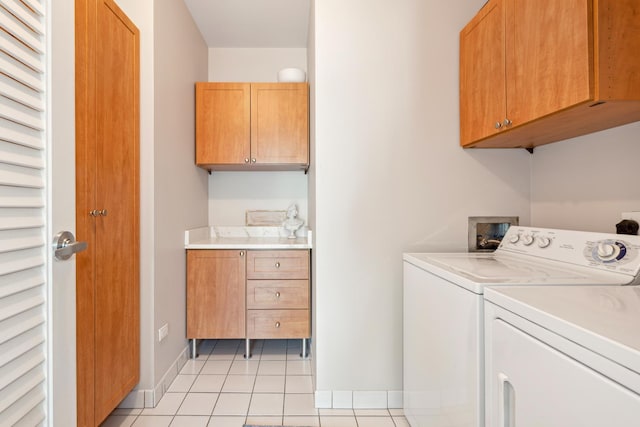 laundry area with baseboards, light tile patterned flooring, cabinet space, and washer and dryer