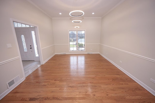 entryway with light hardwood / wood-style floors and crown molding