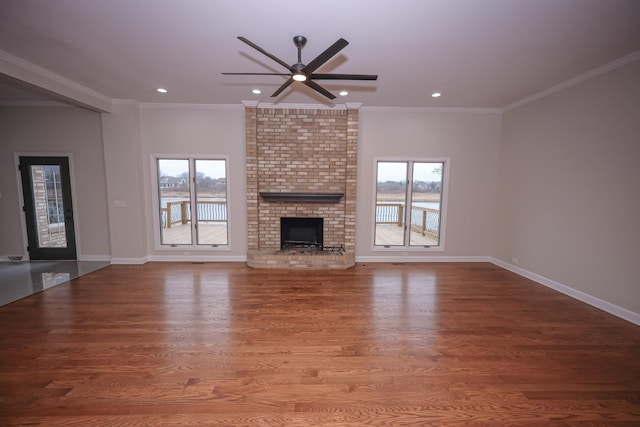 unfurnished living room featuring crown molding, a healthy amount of sunlight, and hardwood / wood-style flooring