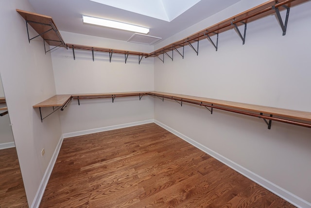 spacious closet with dark hardwood / wood-style flooring