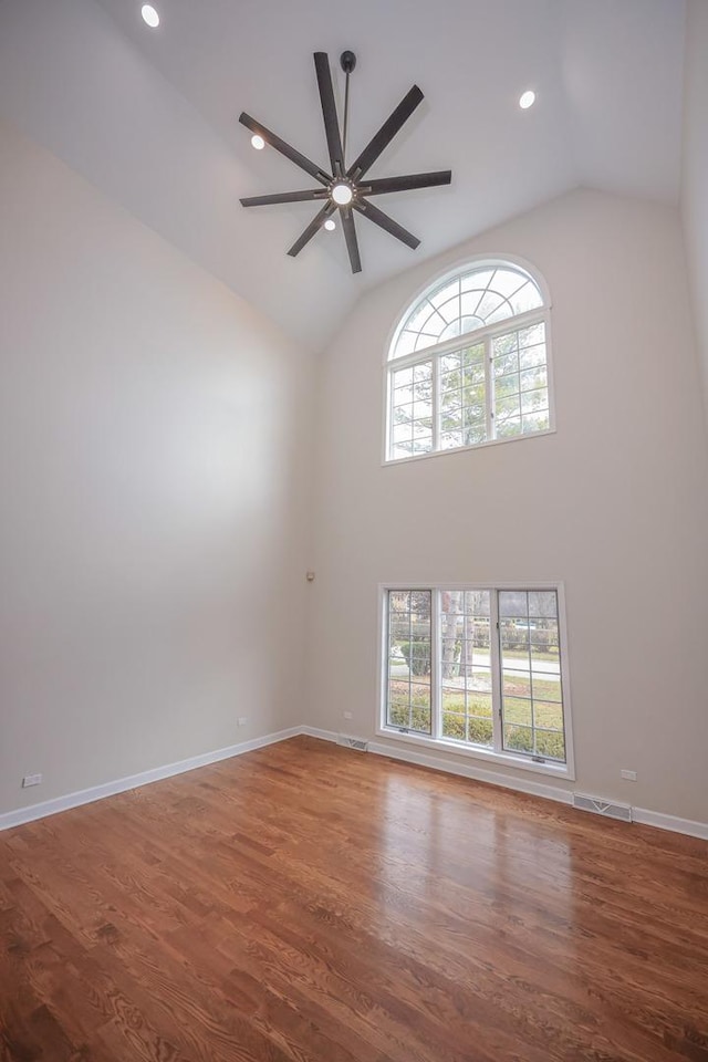 unfurnished room with hardwood / wood-style flooring, high vaulted ceiling, a wealth of natural light, and ceiling fan