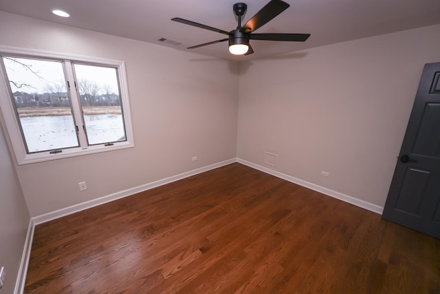 empty room with dark hardwood / wood-style floors and ceiling fan