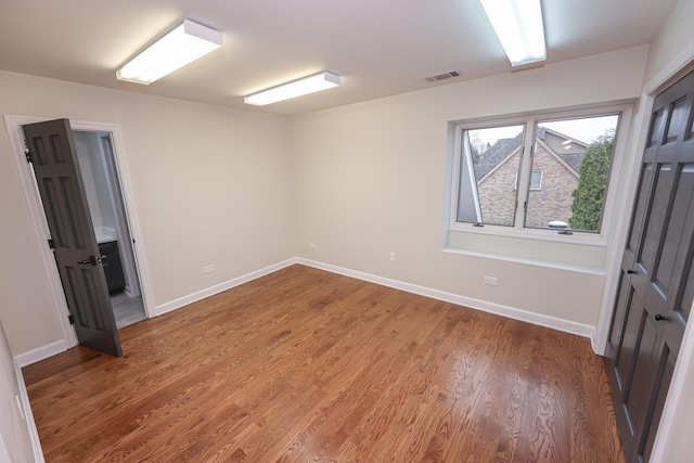 spare room with wood-type flooring